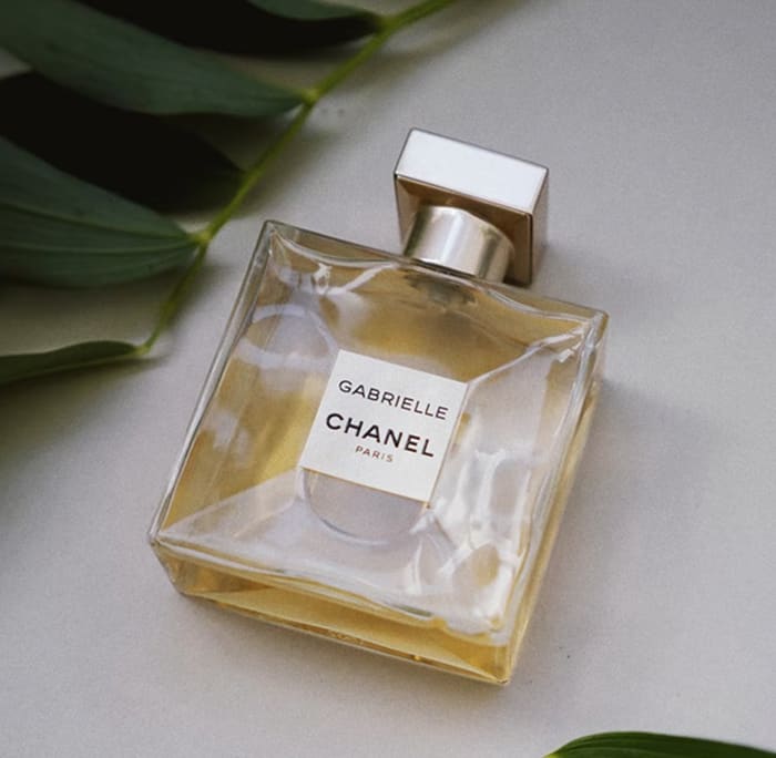 Image of a perfume bottle on a white background with leaves